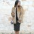 Una maxi pelliccia ecologica e un paio di ankle boots dorati